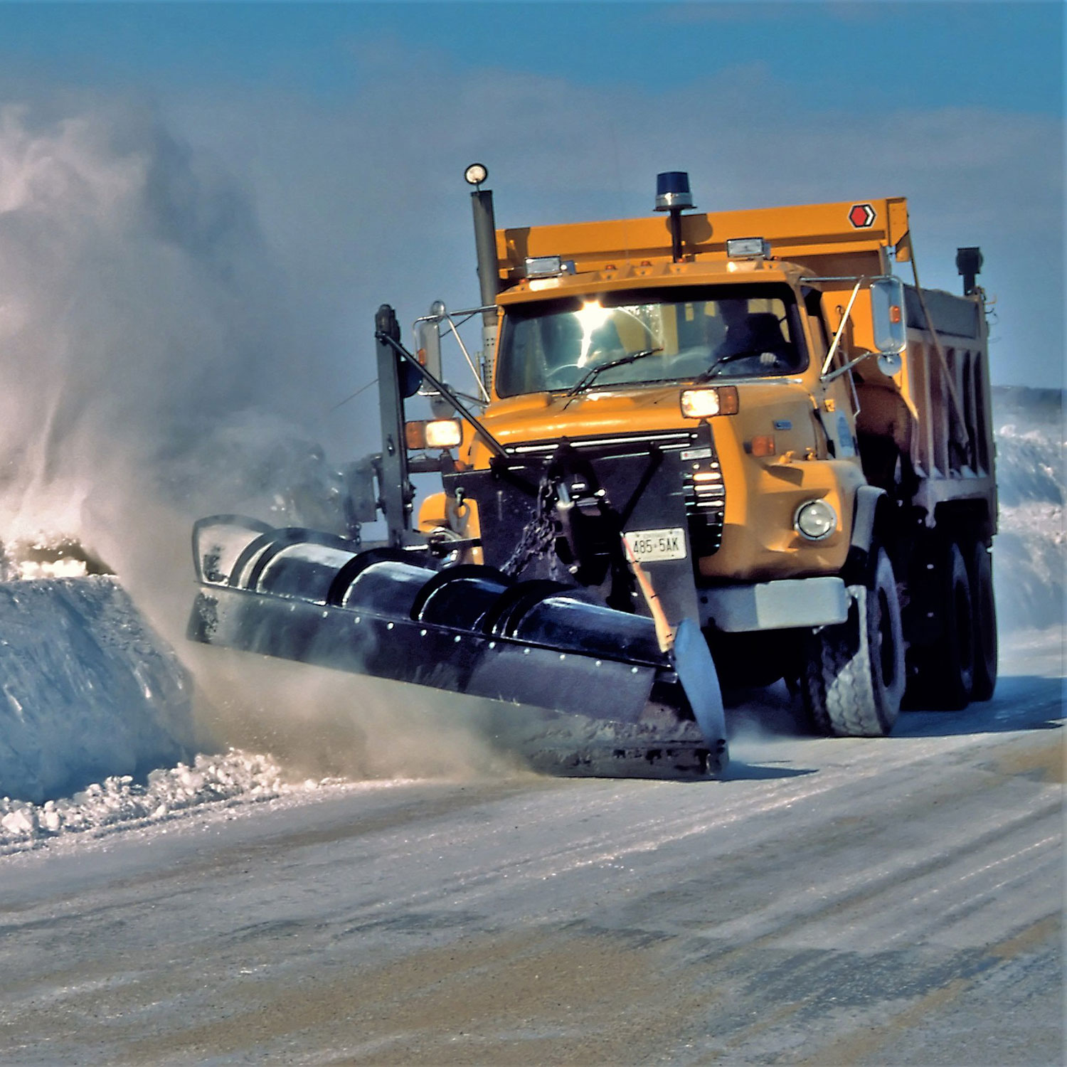 rubber snow blade clearing snow on road